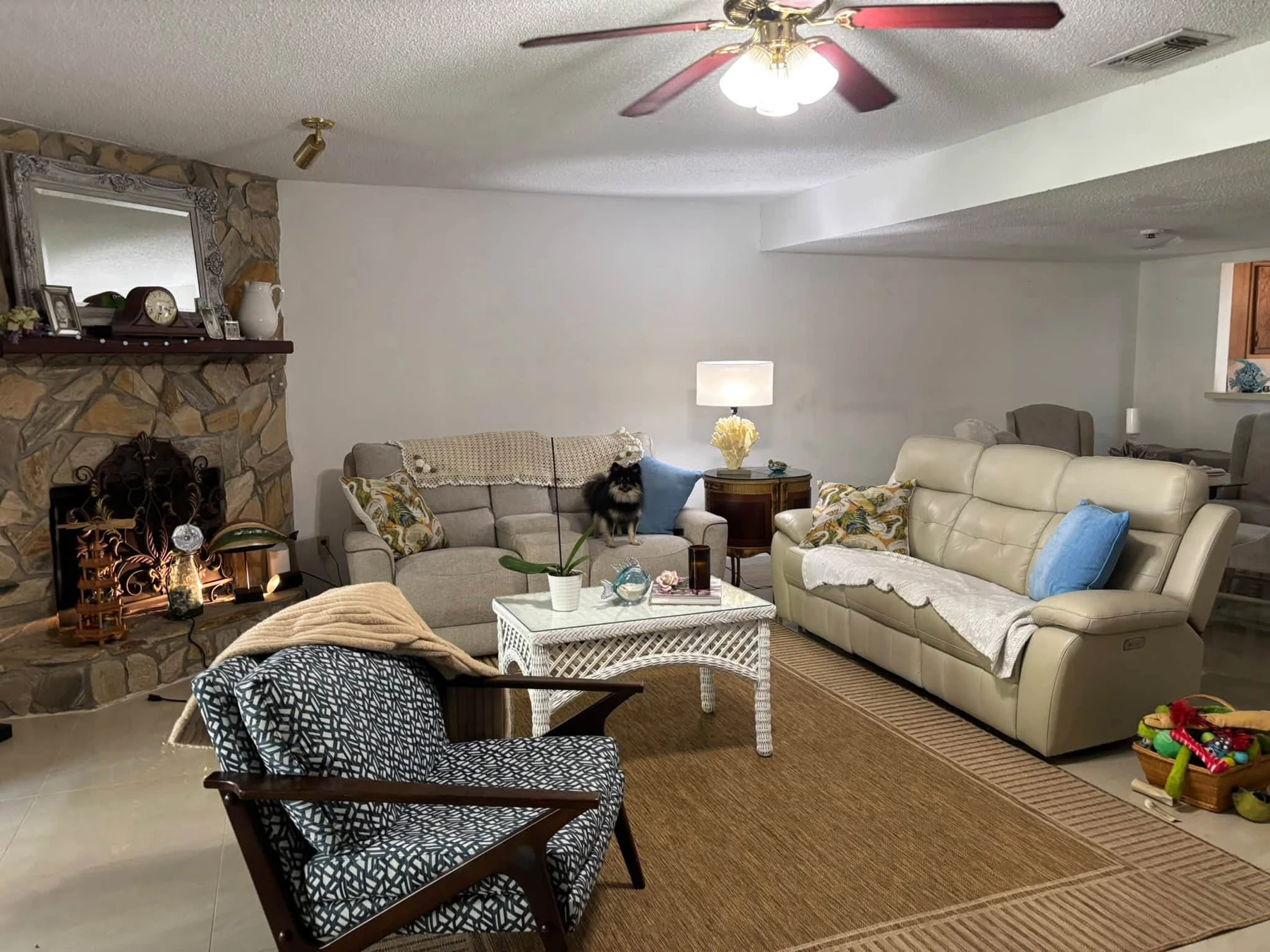 A welcoming living room with cream sofas and a stone fireplace