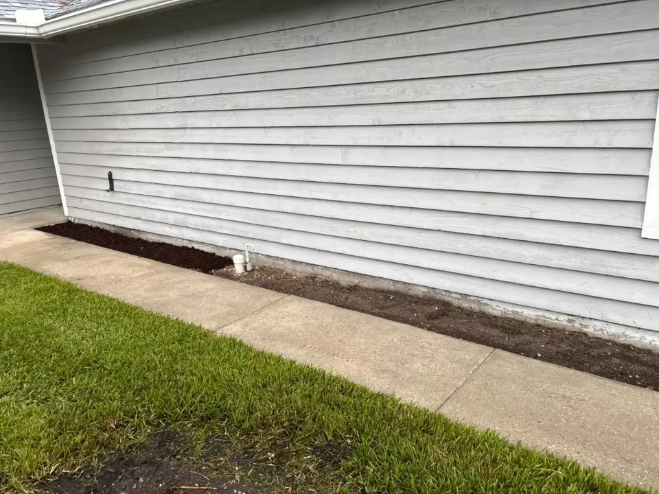 A clear concrete walkway along the side of a home